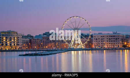 Panoramablick auf die Nacht Blick auf das beleuchtete Riesenrad an der Küste von Bari, Apulien, Italien. Apulien. Panorama Stockfoto