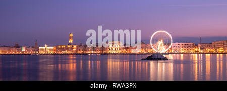 Panoramablick auf die Nacht Blick auf das beleuchtete Riesenrad an der Küste von Bari, Apulien, Italien. Apulien. Panorama Stockfoto