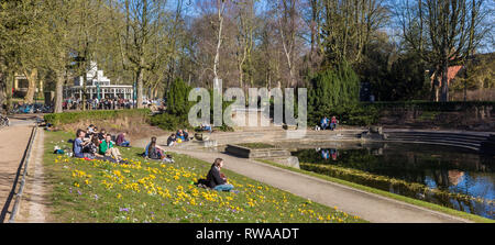 Die Menschen genießen die ersten warmen Tage an der zentralen Teich im Noorderplantson Park in Groningen Stockfoto