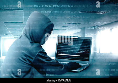 Hacker in Schwarz mit Laptop auf dem Schreibtisch zu hacking System mit binären Code hoodie und laden Sie die Malware im Zimmer Stockfoto