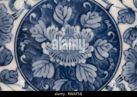 Abstrakte Keramik blau und weiß japanische Blumenkunst design imari Blech Hintergrund Nahaufnahme overhead Foto mit einzelnen Blumen auf blau Stockfoto