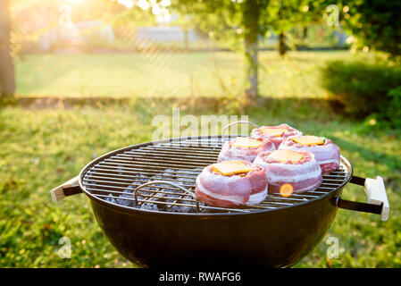 Die hausgemachte Bier kann Bacon Burger am Grill zubereitet. Vorbereitung gefüllte Pastetchen, in Speck umwickelt und Grillen auf indirekte Hitze in der Natur an der Bac Stockfoto