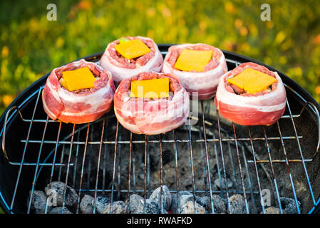 Die hausgemachte Bier kann Bacon Burger am Grill zubereitet. Vorbereitung gefüllte Pastetchen, in Speck umwickelt und Grillen auf indirekte Hitze in der Natur an der Bac Stockfoto