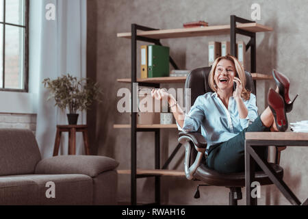 Blonde Rechtsanwalt Gefühl überrascht Anruf empfangen von alten Freund Stockfoto