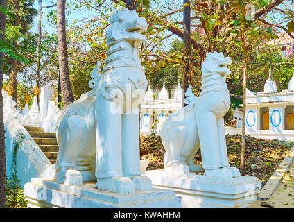 Die weiße Statuen von chinthe (leogryphs, royal Lions) im Garten einer der Eingang zu Shwethalyaung Buddha Tempel, Bago, Myanmar. Stockfoto