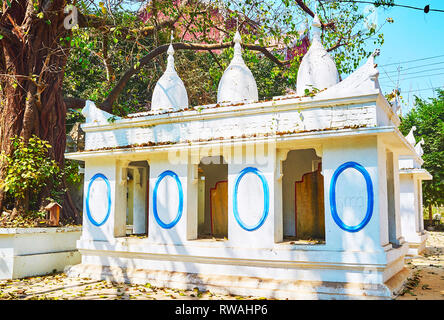 Die weißen Heiligtum der Shwethalyaung Buddha Tempel ist mit kleinen Gips stupas auf dem Dach eingerichtet und geschnitzten Dekore, Bago, Myanmar. Stockfoto