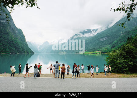 Touristen fotografieren und genießen die Norwegischen Fjord- und Berglandschaft im Oldevatnet in Stryn Norwegen. Stockfoto