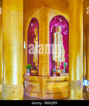 BAGO, MYANMAR - Februar 15, 2018: das Innere von Ananda Stil Tempel des Mahazedi Pagode mit goldenen Buddha Bilder in rot Nischen, am 15. Februar in Bago. Stockfoto
