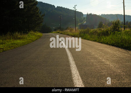 Straße mit einem weißen Trennlinie durch eine Landschaft Stockfoto