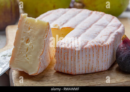 Rundes Stück französischer Käse Fleur Rouge aus Kuhmilch hergestellt als Dessert serviert mit frischen Feigen und Birnen Nahaufnahme Stockfoto