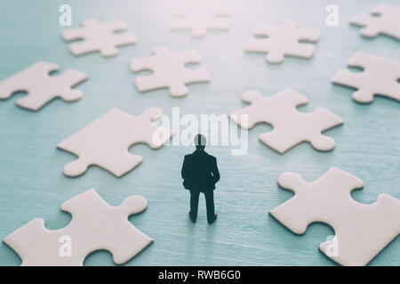 Puzzle Bausteine mit Miniatur Menschen über Holztisch, Human Resources, Problemlösung und Management Konzept Stockfoto