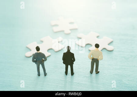Puzzle Bausteine mit Miniatur Menschen über Holztisch, Human Resources, Problemlösung und Management Konzept Stockfoto