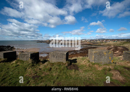 Auf der Suche über die getreidespeicher an Elie Hafen von Ruby Bay mit DEM ZWEITEN WELTKRIEG konkrete Bausteine in den Vordergrund und schneebedeckten spitze Hügel im Hintergrund Stockfoto