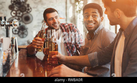 Freunden Bier trinken und plaudern am Zähler in Pub Stockfoto