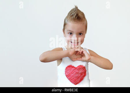 Schönes Kind Junge lächelnd zeigt Herz unterzeichnen. Portrait Kind blond 6 Jahr mit Lächeln, Hände Geste der Liebe. Studio isoliert weißer Hintergrund. Stockfoto