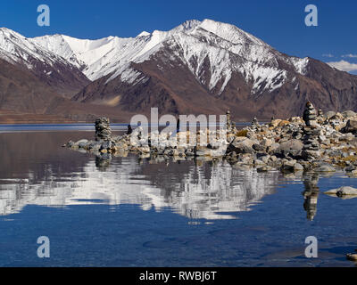 Stein buddhistischen Stupas und Spiegelbilder von Bergen auf der Oberfläche des Wassers des Sees Pangong, Jammu und Kaschmir, Indien. Stockfoto