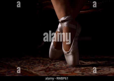 Die Schuhe und Füße einer Ballerina in geschlossenen Räumen Stockfoto