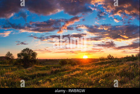 Sommer helle Landschaft. Bewölkter Sonnenuntergang über der Steppe Hügel. Bewölkter Himmel und Sonnenlicht. Die ukrainische Landschaft. Kriviy Rih Stockfoto