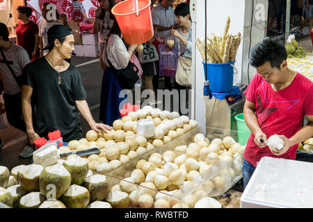 Singapur - Januar 28, 2019: - Verkäufer, frische junge Kokosnüsse in einer Straße Shop in China Town in Singapur Stockfoto