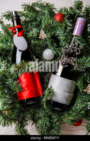 Foto von zwei Weihnachten Flaschen mit sauberem Grußkarte auf Ästen Fichte Stockfoto