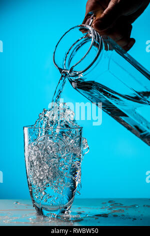 Man gießt Wasser aus Glas Stockfoto