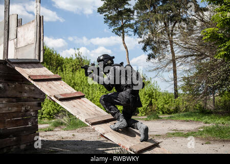 Spec Ops Polizeioffizier SWAT in schwarzer Uniform in Aktion. Stockfoto