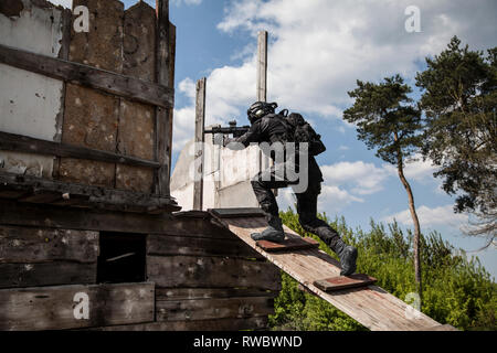 Spec Ops Polizeioffizier SWAT in schwarzer Uniform in Aktion. Stockfoto