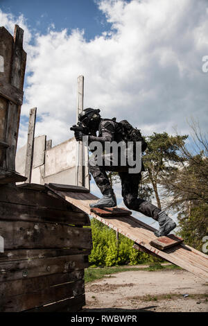 Spec Ops Polizeioffizier SWAT in schwarzer Uniform in Aktion. Stockfoto