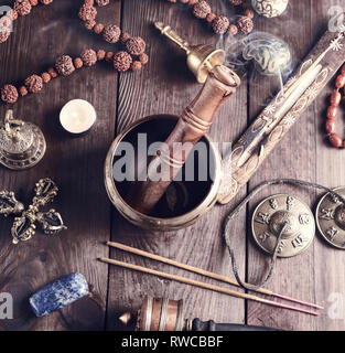 Tibetischen religiösen Objekte für Meditation und alternative Medizin auf braunem Holz- Hintergrund, Ansicht von oben Stockfoto