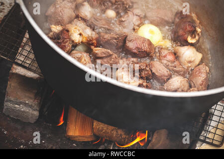 Lamm und Gemüse werden in einem Kessel. Vorbereitung der Chorba Suppe auf offenem Feuer, traditionelle Mahlzeit für viele nationale Küchen Stockfoto