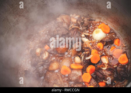 Lamm mit Gemüse Eintopf in einem Kessel. Vorbereitung der Chorba Suppe auf offenem Feuer Stockfoto