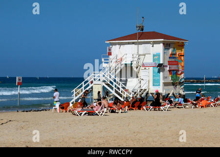 Beachgoers Lounge in der Nähe von einem weißen Strand Hütte an den Ufern des Mittelmeers in Tel Aviv am Schabbat. Stockfoto