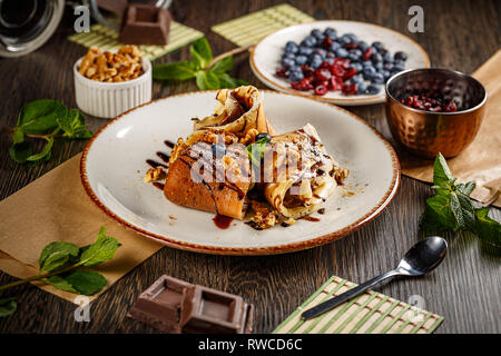 Crepes oder Pfannkuchen mit Schokolade und Sahne Walnüsse Stockfoto