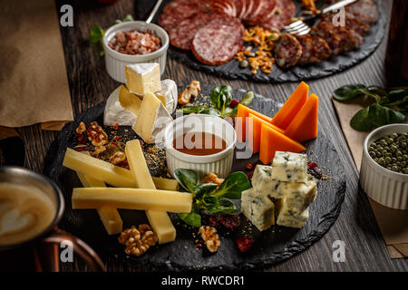 Vorspeise Tabelle mit Antipasti Snacks. Fleisch und Käse Vielfalt Brett über Holz- Hintergrund Stockfoto