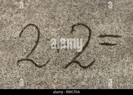 Mathematische Gleichung. Zwei plus Zwei auf Sand Hintergrund Stockfoto