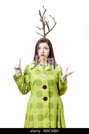 Clown stehend in Anzug schockiert und gestikulierend auf weißem Hintergrund. Ein Zweig wächst aus seinem Kopf. Zeigt mit dem Finger nach oben. Stockfoto