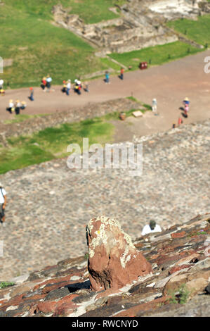 Rock in der Wand auf der Pyramide der Sonne in Teotihuacan mit Besuchern zu Fuß auf der Straße der Toten, Mexiko Stockfoto