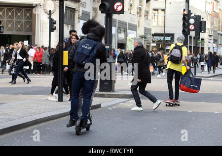 Bild zeigt: Skateboarder und Elektroroller, die Probleme verursacht, auf dem Bürgersteig und auf der falschen Seite der Straße in der Oxford Street. Diese Fußgängerzone w Stockfoto