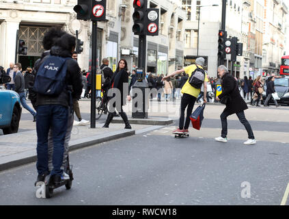 Bild zeigt: Skateboarder und Elektroroller, die Probleme verursacht, auf dem Bürgersteig und auf der falschen Seite der Straße in der Oxford Street. Diese Fußgängerzone w Stockfoto