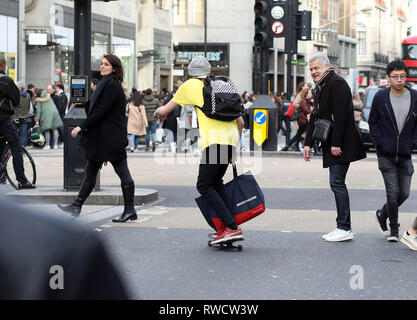 Bild zeigt: Skateboarder und Elektroroller, die Probleme verursacht, auf dem Bürgersteig und auf der falschen Seite der Straße in der Oxford Street. Diese Fußgängerzone w Stockfoto