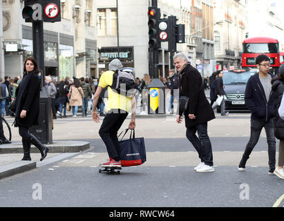 Bild zeigt: Skateboarder und Elektroroller, die Probleme verursacht, auf dem Bürgersteig und auf der falschen Seite der Straße in der Oxford Street. Diese Fußgängerzone w Stockfoto