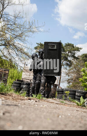 Spec Ops Polizisten SWAT in schwarzer Uniform in Aktion. Stockfoto