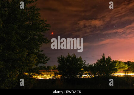 Blut Mond auf die dunkle Nacht bewölkter Himmel über der Landschaft. Full Moon eclipse am 27.07.2018 in der Ukraine, Kriviy Rih. Stockfoto