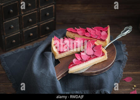 Hausgemachter Erdbeerkuchen oder Torte geschnitten auf hölzernen Platte auf der rustikalen Hintergrund Stockfoto