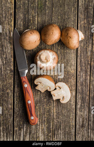 Frische champignon Pilze auf alten Holztisch. Stockfoto