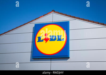Die Lidl unterzeichnen und Logo gegen einen strahlend blauen Himmel an der Vorderseite der Lidl in Farnham, Surrey. Stockfoto