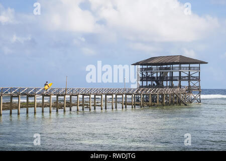 Der einsame Surfer Wandern mit gelben Brett - Boardwalk auf Wolke 9 - Siargao, Philippinen Stockfoto