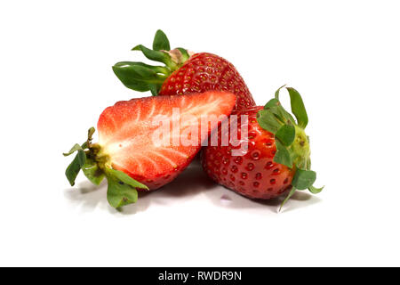 Zwei ganze Erdbeere Früchte und die Hälfte isoliert auf weißem Hintergrund Stockfoto