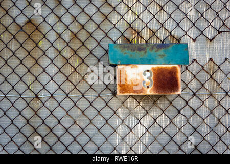 Eine alte und rostige Mailbox eine verrostete Kette Maschendrahtzaun mit einer Nummer 3 Stockfoto
