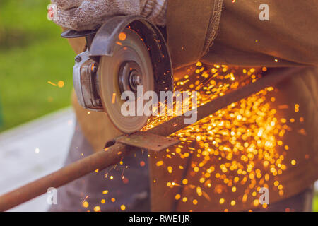 Schneidmesser Grinder close-up mit Funkenflug der Metall während des Schneidprozesses Stockfoto